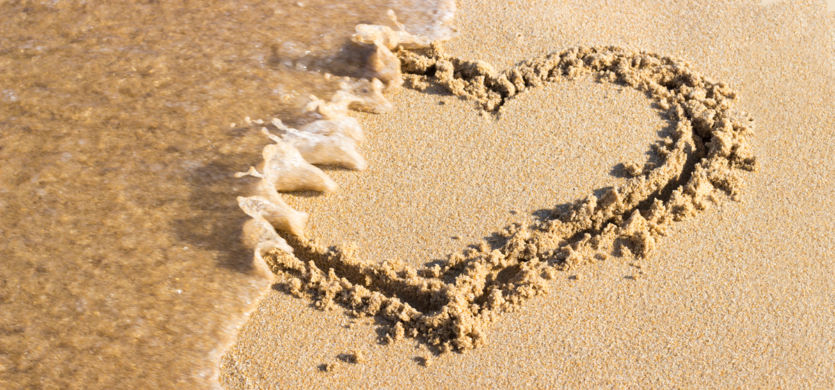 Ein in den Sand gezeichnetes Herz am Strand